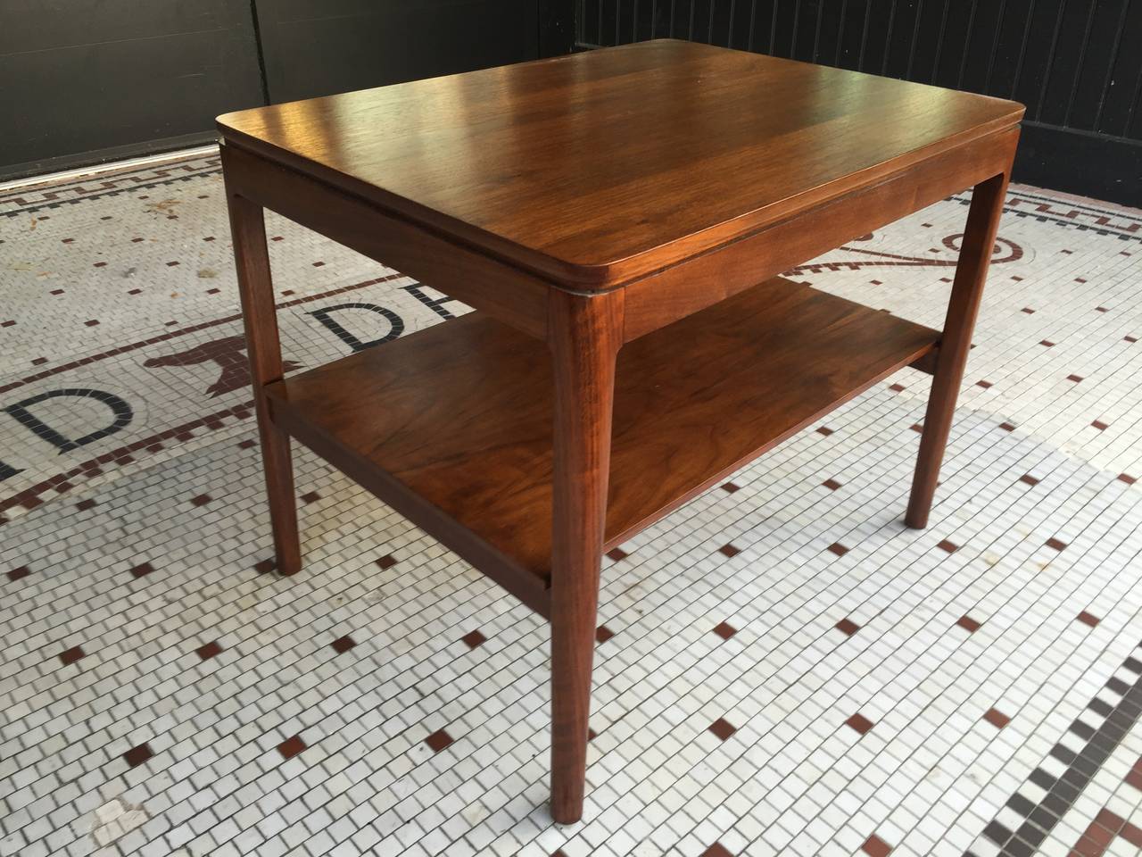 Dunbar two-tier side table by Drexel of rectangular form with recessed edge and slight tapering legs. Expertly finished.