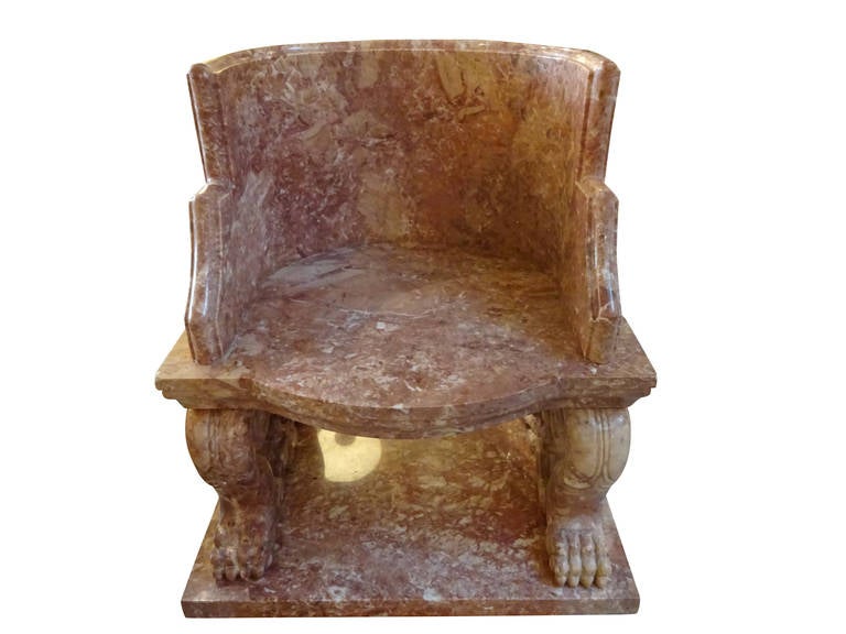 A large Greek/Roman style marble chair. With unusual curved back and finely carved details. Raised on paw scroll feet.