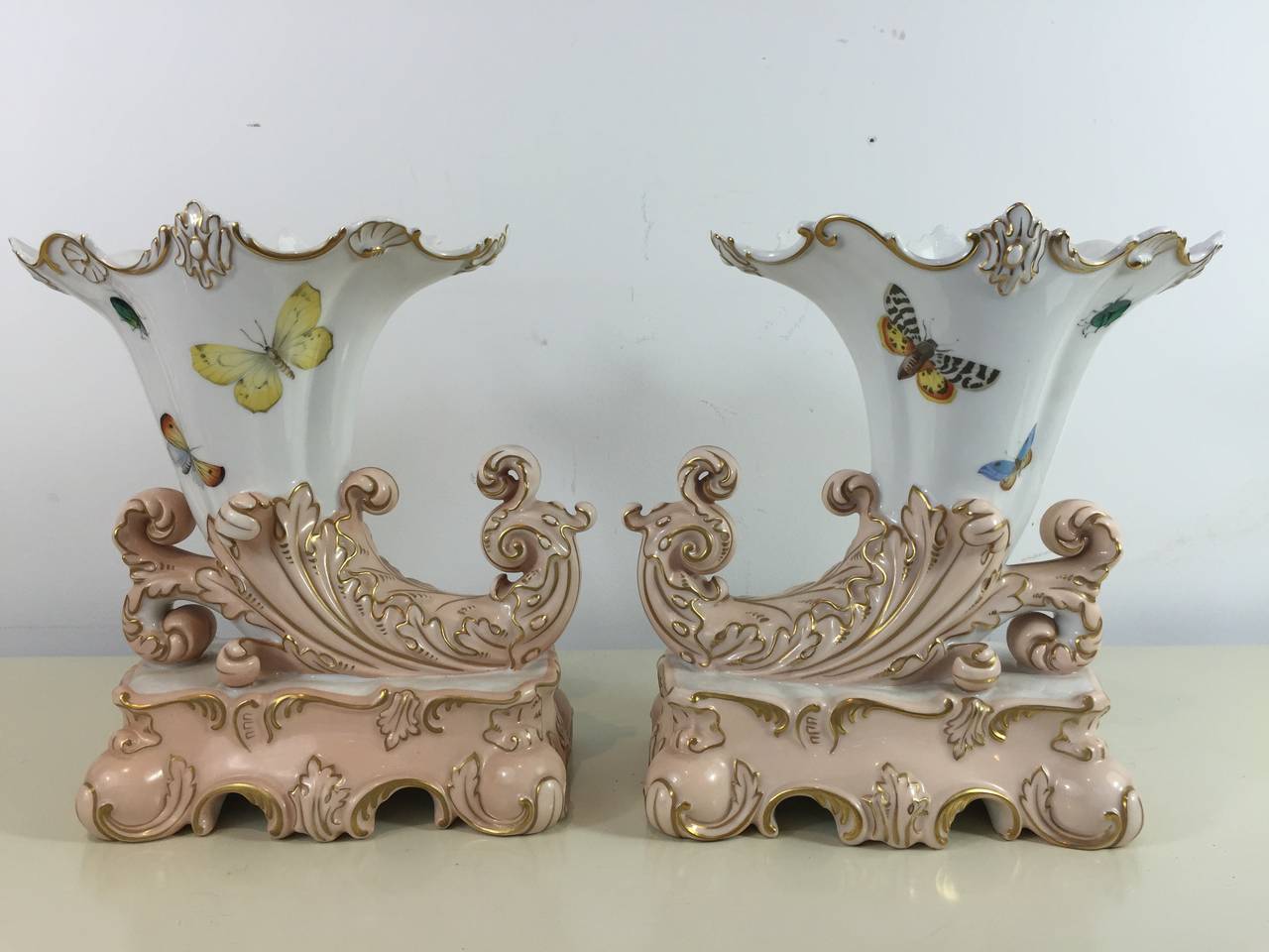 Robinson and Leadbeater (R&L) Naturalistic Cornucopia mantel vases, each one decorated with butterflies and insects, with salmon and gilt highlights.