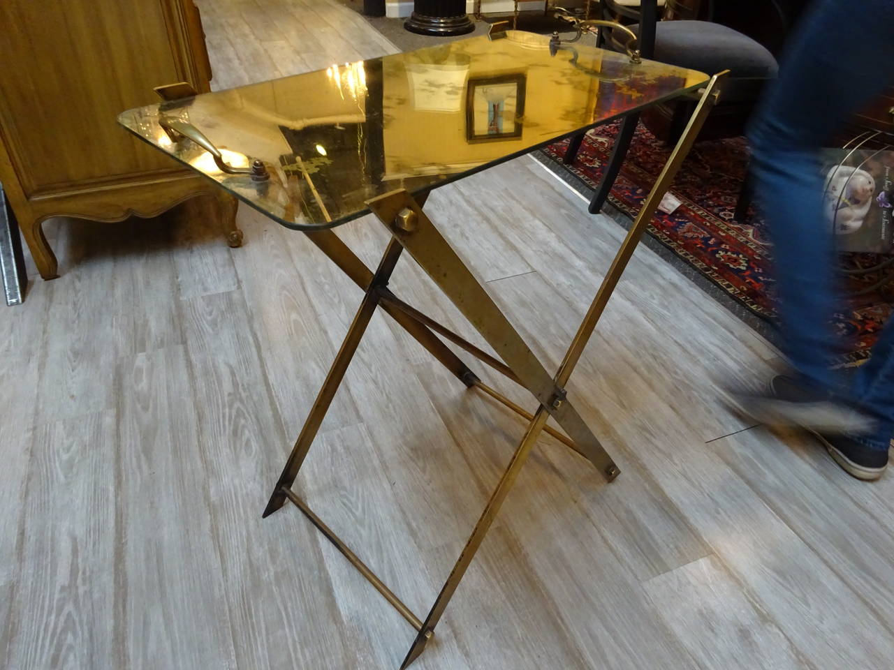 A brass folding base butler's tray with antiqued mirrored top with handles.