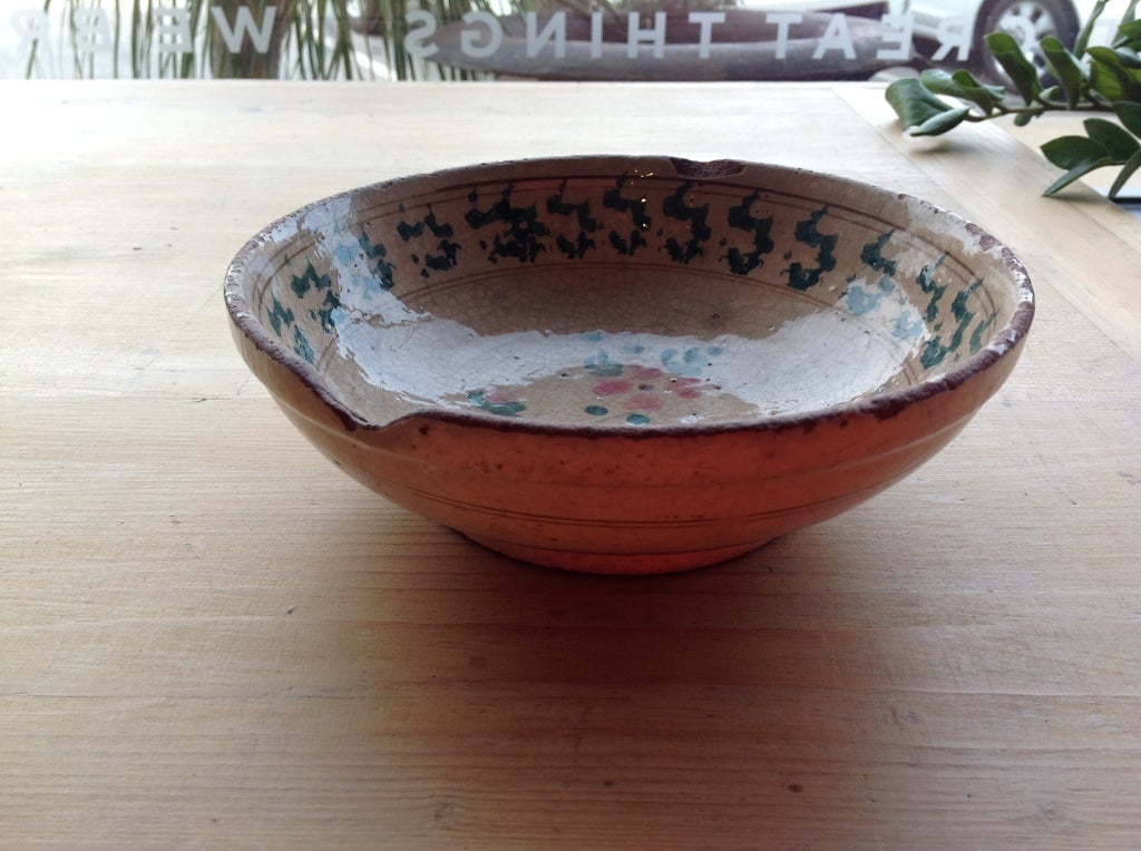 This is a lovely example of a typical antique bowl from Puglia, in the south of Italy.  This is a traditional shape, glazed with a flower pattern using two colors.  Some chips and wear to the glaze add charm to this 19th century bowl. Decorative use
