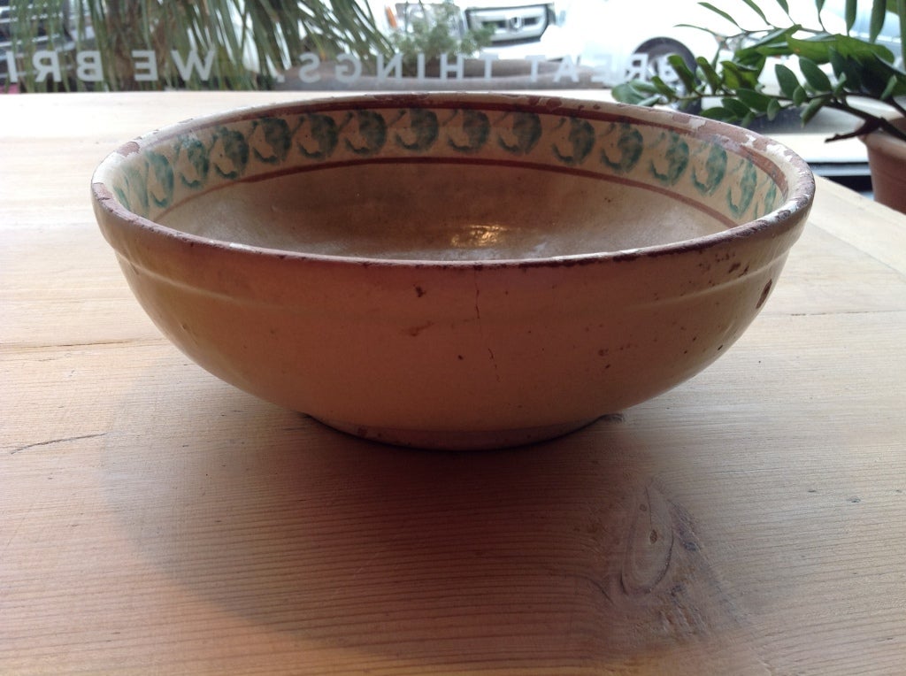 This antique bowl from Puglia, in the south of Italy has a great pattern of interlinked circles.  This is a traditional shape, glazed with a traditional pattern in a typical color.  Some chips and wear to the glaze add charm to this 19th century