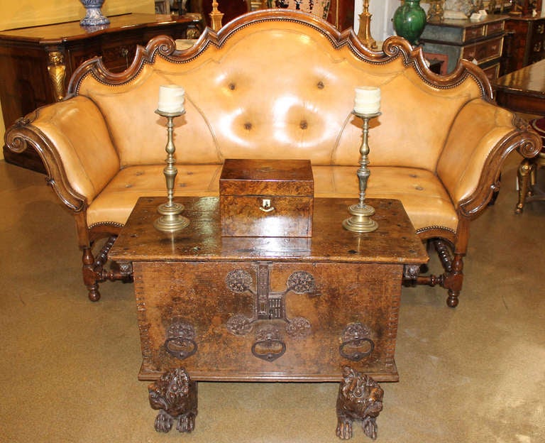 An 18th century Piedmontese walnut sofa, with an upholstered camel back flanked by out swept arms raised on turned legs connected with conforming perimeter stretch and now upholstered (front and back) in C. Mariani antiqued glazed leather with