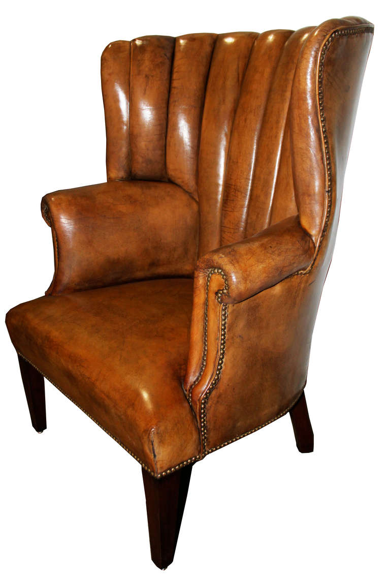 An impressive 19th century English leather library chair, with a rare flaring comb back, accented with nailhead trim and raised on squared tapering legs. Two C. Mariani Antique reproductions in C. Mariani custom leather available for immediate