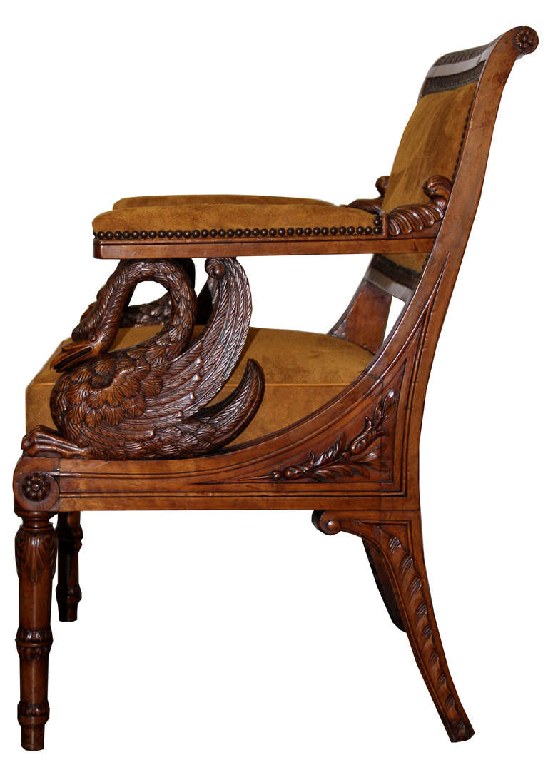 An unusual 19th century Italian Empire walnut armchair with elegant swan carvings (symbol of Josephine of France) on its sides, raised on turned and shaped baluster legs and now upholstered in C. Mariani suede leather.