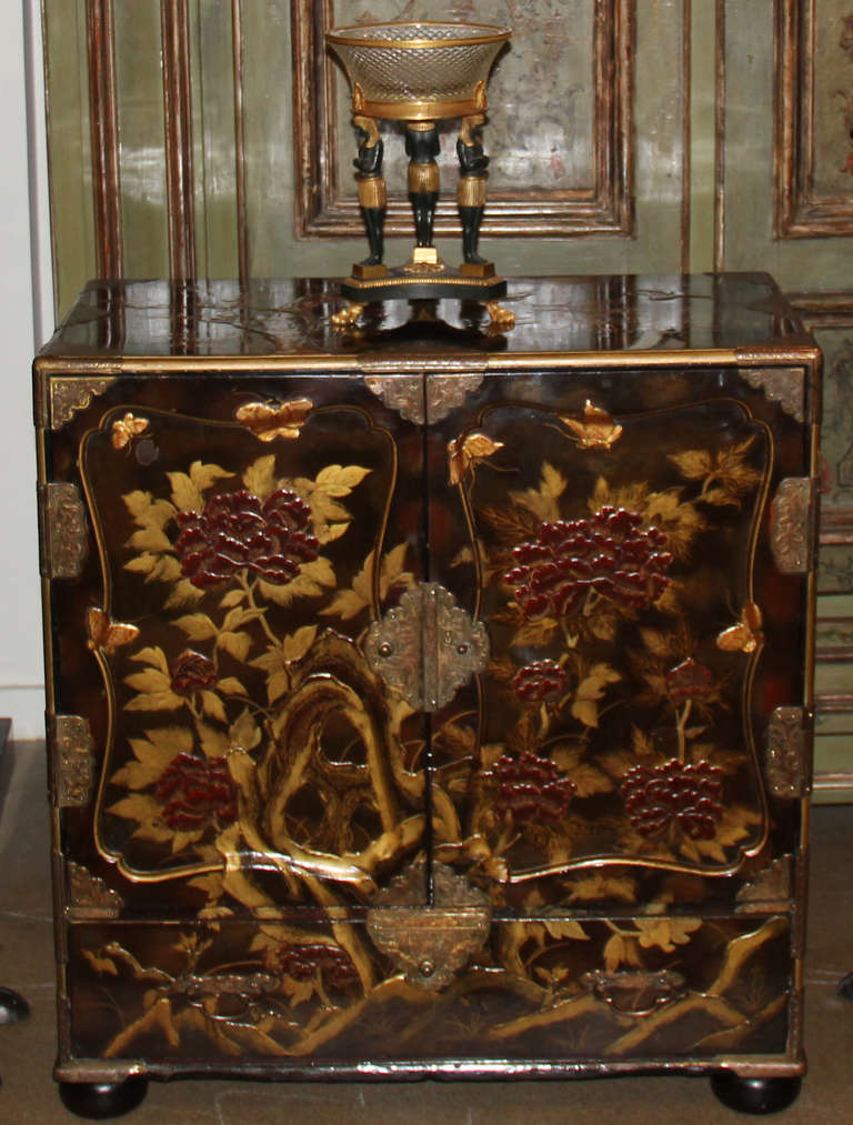 Gabinete japonés de laca color ciruela del siglo XIX, decorado con sutiles peonías, pájaros y flores de cerezo dorados y burdeos, las puertas delanteras se abren para revelar siete cajones de almacenaje, con un cajón adicional debajo de las puertas,