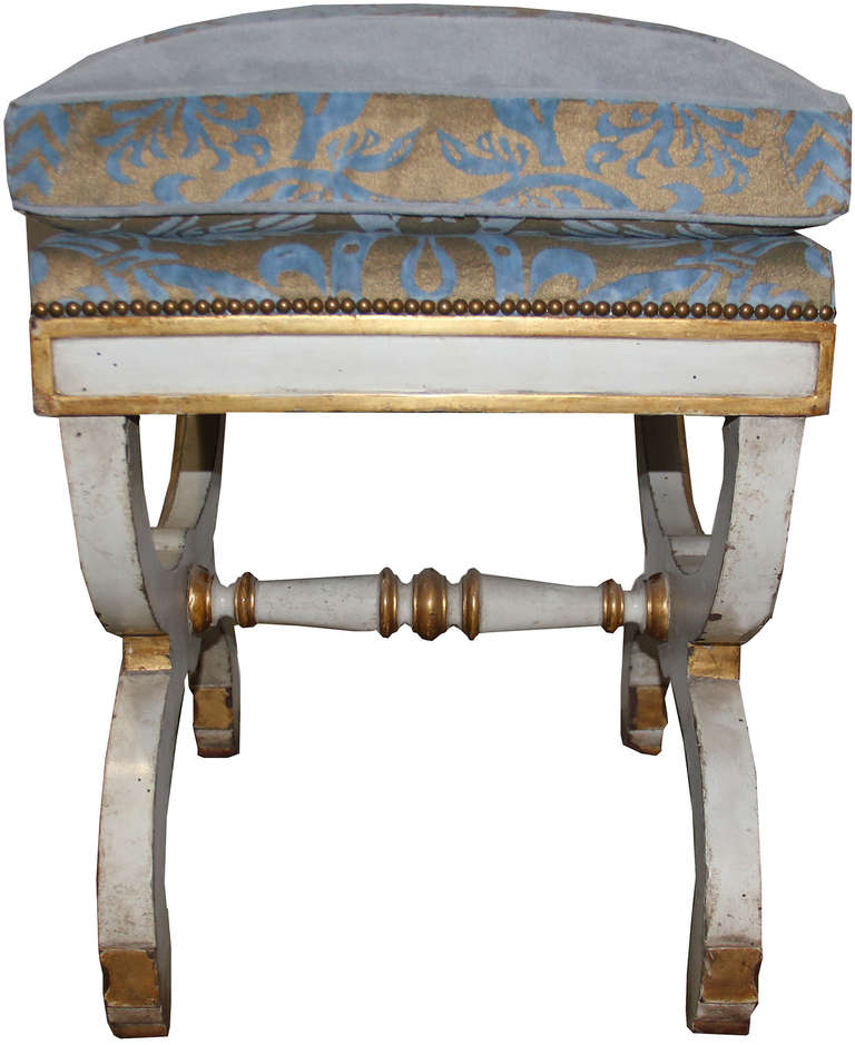 A sophisticated pair of 19th century Italian polychrome and parcel-gilt curule benches, now upholstered in Fortuny fabric.