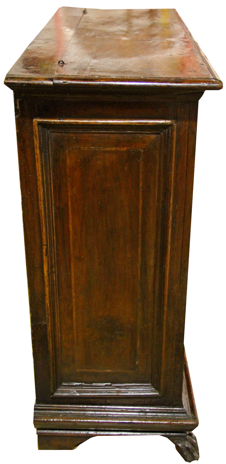 A 17th century Tuscan walnut commodino (small chest of drawers), the molded rectangular hinged top above a faux drawer (opening for storage) above two drawers below with turned rounded knobs and heart shaped keyholes, with the whole raised on lion