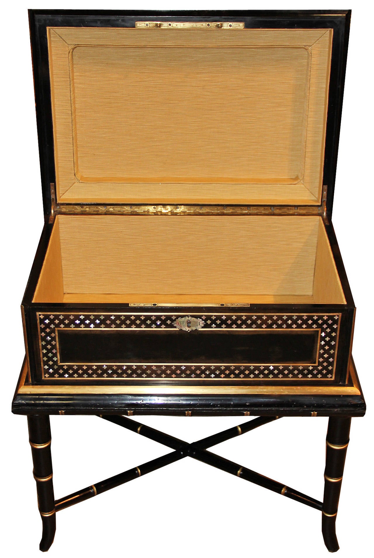 A 19th century Anglo-Indian ebonized box on stand, the top centered by mother-of-pearl and rocaille brass inlay, framed by a mother-of-pearl quatrefoil inlay and brass trim, continuing along the sides, with a mother-of-pearl escutcheon at the front