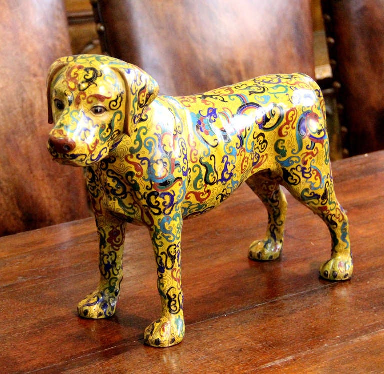 A Whimsical Cloisonné dog in a kaleidoscope of color against a bright yellow ground.
