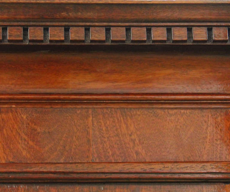 An 18th century English mahogany linen press crested with denticulated molding above two large doors and two long lower drawers, the whole raised on shaped bracket feet.