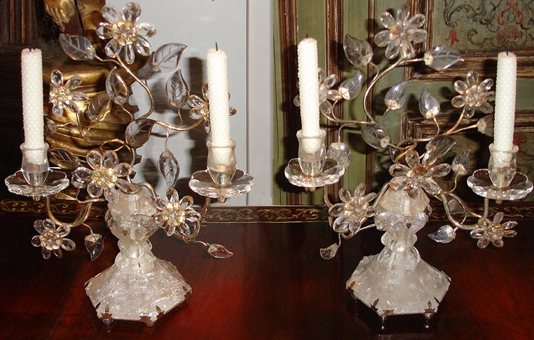 A glittering pair of 19th century Italian Empire rock crystal girandole candelabra with delicate brass tracery and mounts, each holding intricately etched and cut crystal floral and foliate motifs surrounding two candle arms with flower petal rock