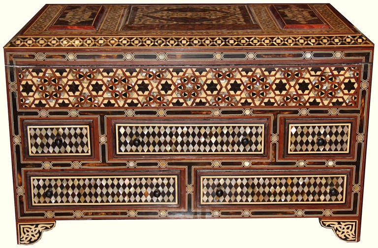 A unique and palatially scaled 19th century Levantine valuables box, the top opening to reveal a large fitted compartment, with bone and mother-of-pearl parquetry inlay covering the top, sides and five fitted drawers in intricate geometric designs