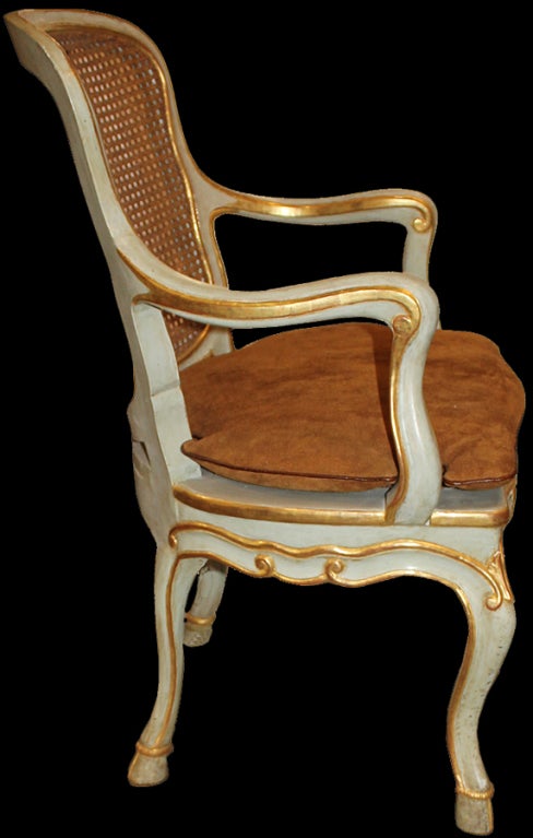 A harlequin set of 12 18th century and later Italian pale blue or green polychrome, parcel gilt and caned Louis XV dining chairs, the gently curving backs demonstrating the emphasis on comfort during the period and complimenting the graceful