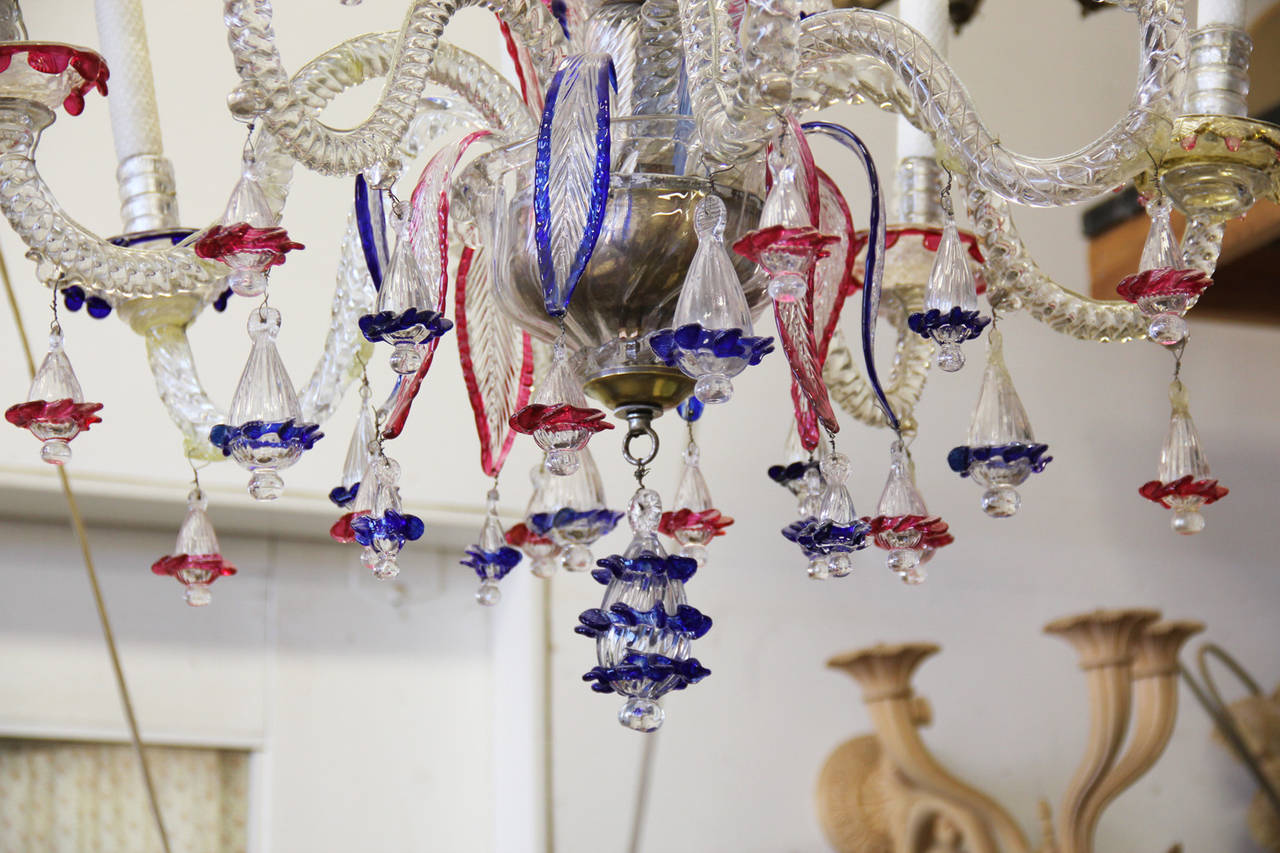 A 19th century Murano blown glass chandelier with six crystal arms emanating from the balustrade standard, embellished with elaborate colored glass acanthus leaves, flowers, and sprays, incorporating blown crystal ornaments with pink, blue, white