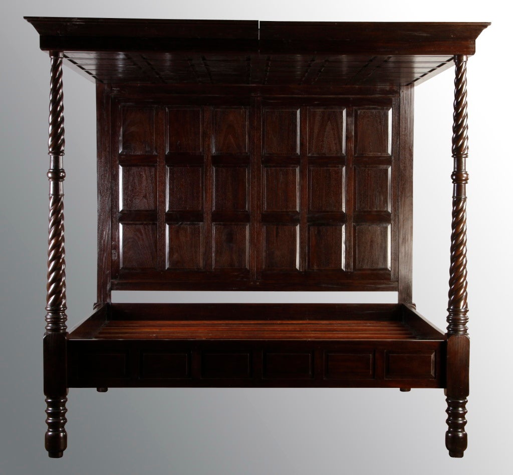 20th century English Jacobean style carved oak king size canopy bed, the canopy and headboard fashioned from recessed panels, all supported by carved barley twist columns.