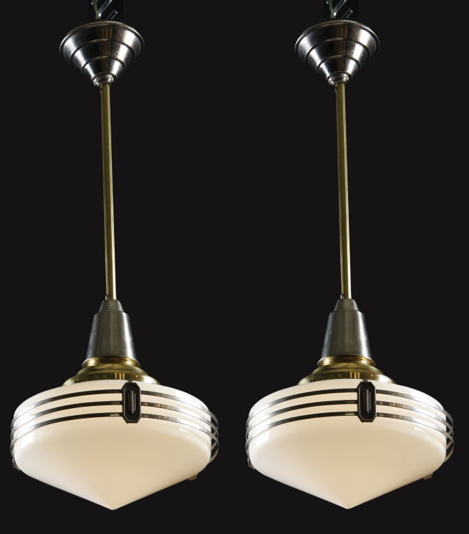 Pair of early to mid 20th century American Art Deco chrome and glass diner style pendant lights with chrome accents.