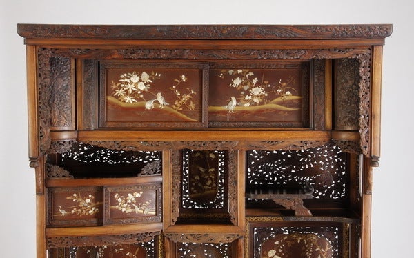 19th century Japanese curio cabinet with carved moulding and pierce carved side and back panels, the asymmetrical interior featuring sliding doors and cabinet style doors with mother-of-pearl and ivory inlaid birds and flowers, and hand painted gilt