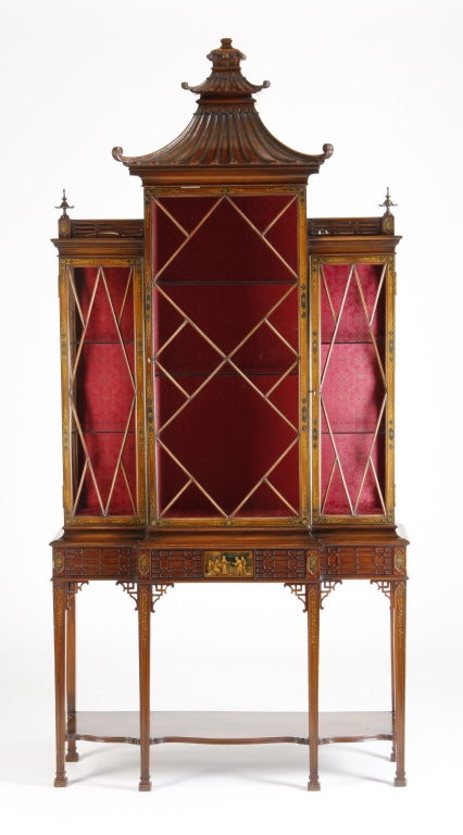 Very fine early 20th century carved mahogany Chinoiserie curio cabinet with a pagoda shaped top, the three doors with individually mortised panes opening to reveal a red damask lined interior and glass display shelves, with lower open display shelf