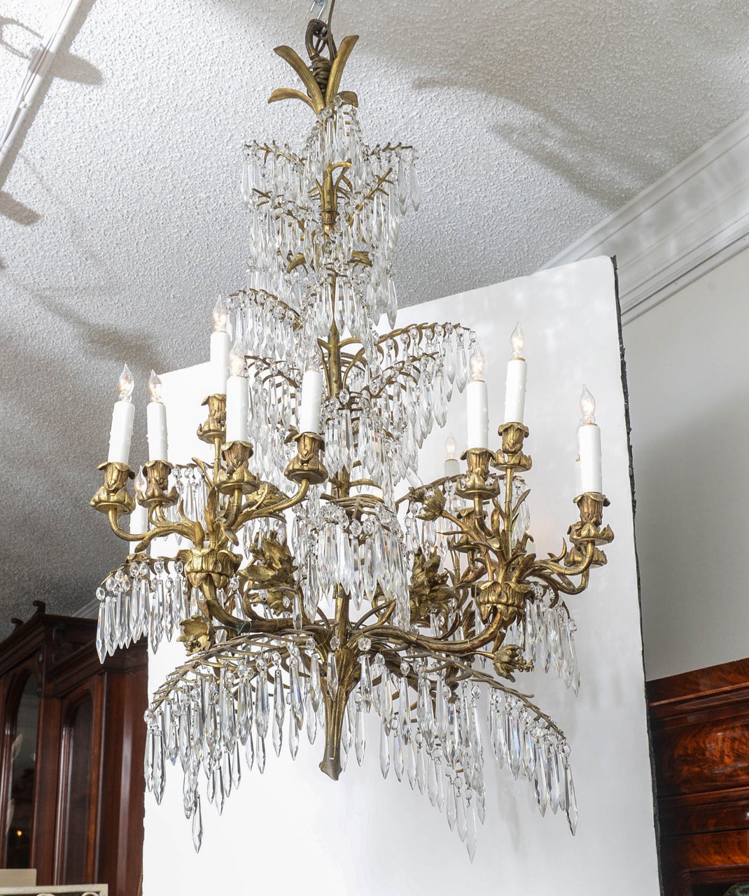 French gilt bronze and drop crystal eighteen-arm chandelier, in the Brighton style of a flowering tree with icicle prisms with wax sleeves, newly wired, original restored condition.