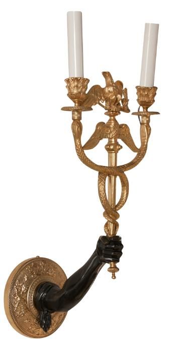 A pair of Napoleon III gilt bronze, ebonized and wax sleeve  wall sconces having a single candle arm in the form of a human arm holding aloft a standard surmounted by an eagle and entwined with two serpents - their heads ending in petal cast nozzle,