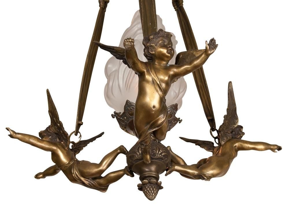 A late 19th century French bronze chandelier with three winged cherubs in flight holding a center frosted flame globe with bronze ribbon straps are holding the cherubs, original restored finish, newly wired.

Originally $ 2,850.00

PLEASE VISIT