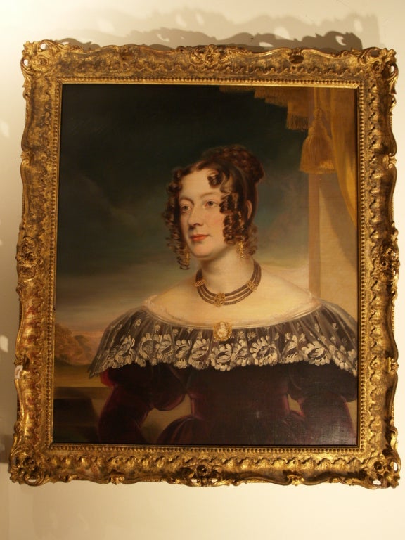 Oil on canvas/in the style of Sir Martin Archer Shee, British School/1830s/ Bust length portrait of a young brunette woman with blue eyes wearing a torque of triple braided hair and gold colored earrings. A gold ringed cameo portrait bust pinned to