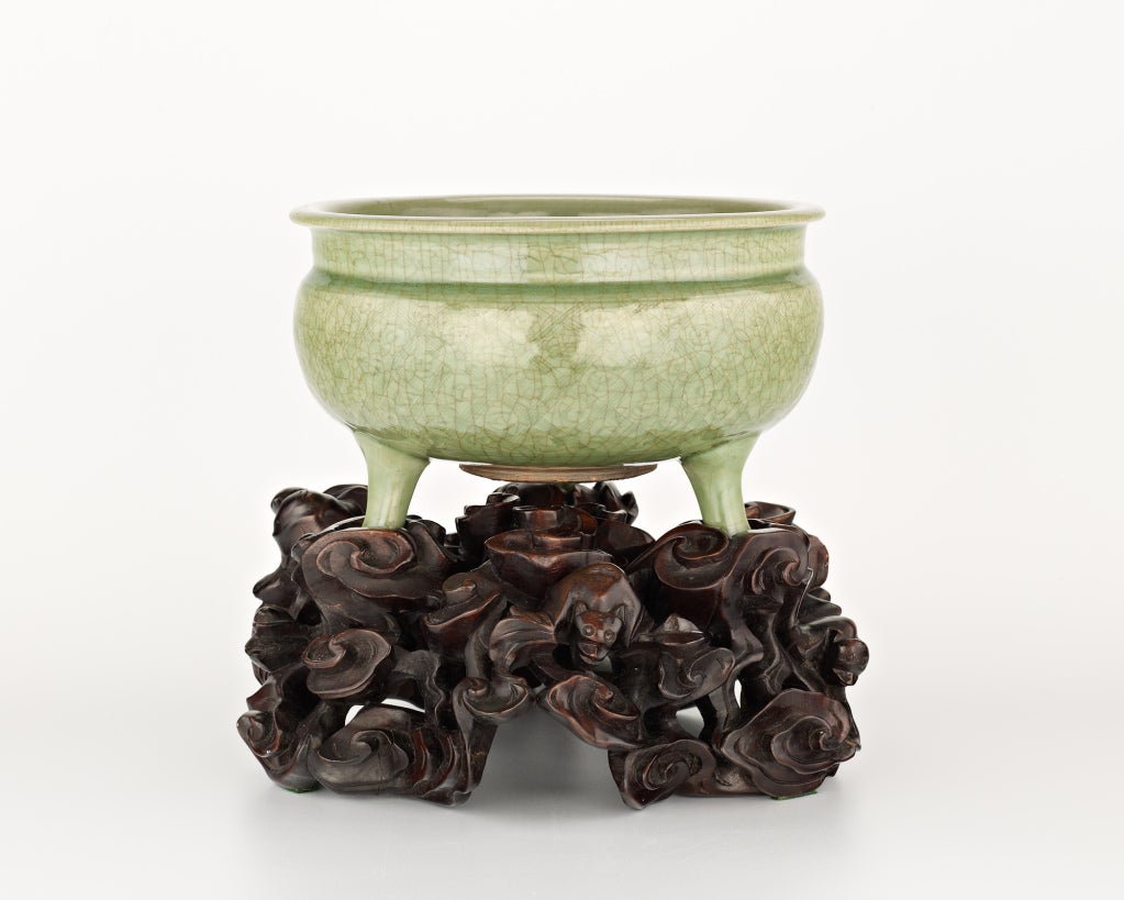 Chinese A large celadon tripod censer on a carved wood stand