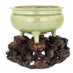 A large celadon tripod censer on a carved wood stand