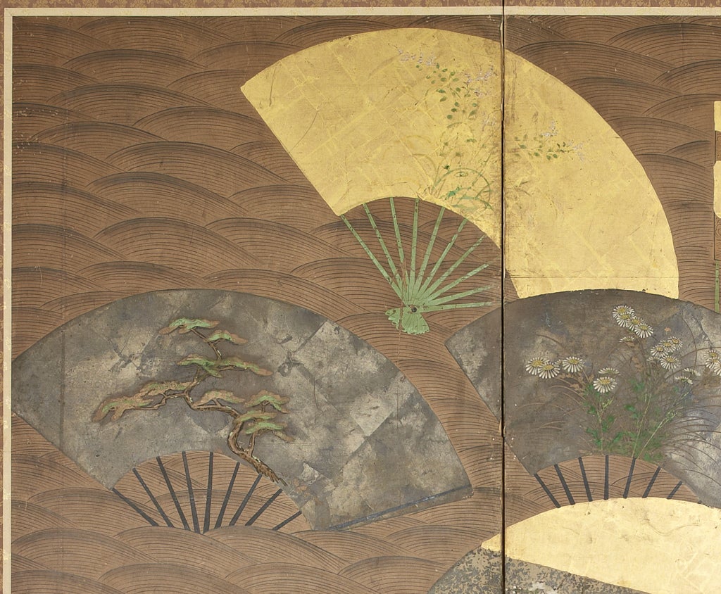 Each screen similarly decorated with gold and silver fans painted with flowers, fruits and other plants, floating over stylized waves bordered by a curving bank lined with reeds bent by the breeze.