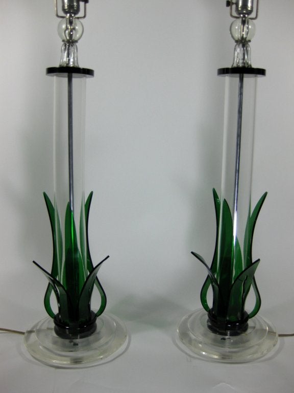 Glamorous 40s tablelamps. Clear lucite base with green lucite palm leaf design. Black lucite circular cap. Glass between lucite base and lighting hardware. Chromed steel rod throughout.  Lucite finial.