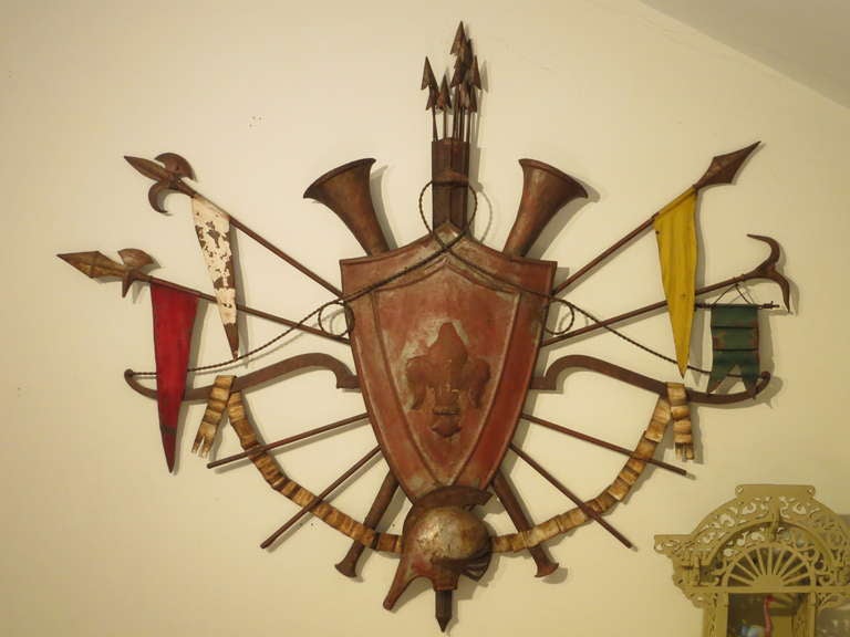 A wonderfully detailed European wall plaque encircled by flags, a quiver of arrows and musical horns. A Roman Gallic helmet rests beneath the shield.