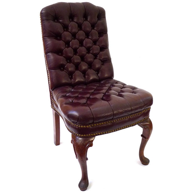 A pair of English Georgian side chairs with later (Victorian) button tufted leather covering. Finished with nail head trim. The curved legs terminate to a pad foot