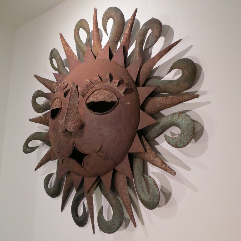 A wonderfully expressive, wall mounted sun. The hand wrought metal is artfully composed to create a whimsical centerpiece for either house or garden. The metal has aged to a great patina