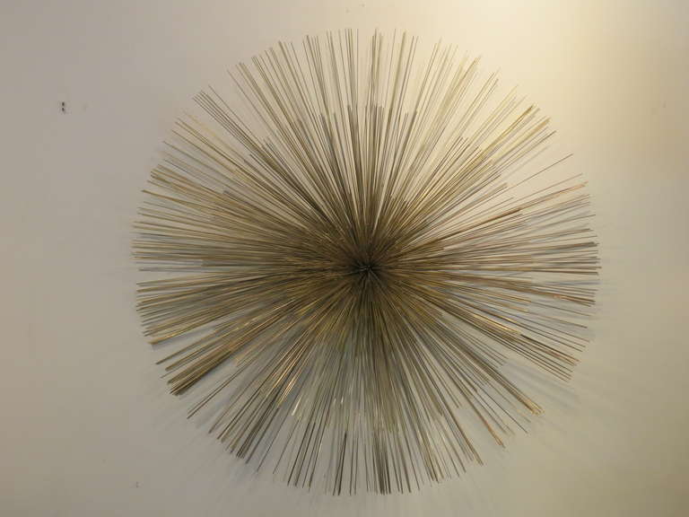 A phenomenal oversized metal sunburst consisting of three layers of slender rods assembled in a three dimensional manner. Signed and dated on back mounting plate.