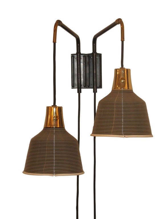 This is a counter-weighted, adjustable two arm lamp produced by the Heifetz Company.  The rotoplex shades are a spun acetate, with alternating black and white ridges. Pull chains (not shown in images) allow each shade to be switched on and off.