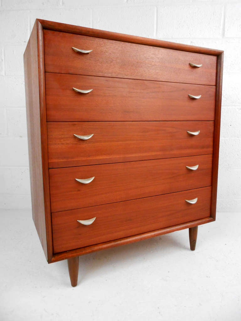 The unique drawer pulls on this midcentury Danish dresser perfectly compliment it's wonderful teak finish, making a stylish storage solution for any home. Please confirm item location (NY or NJ).