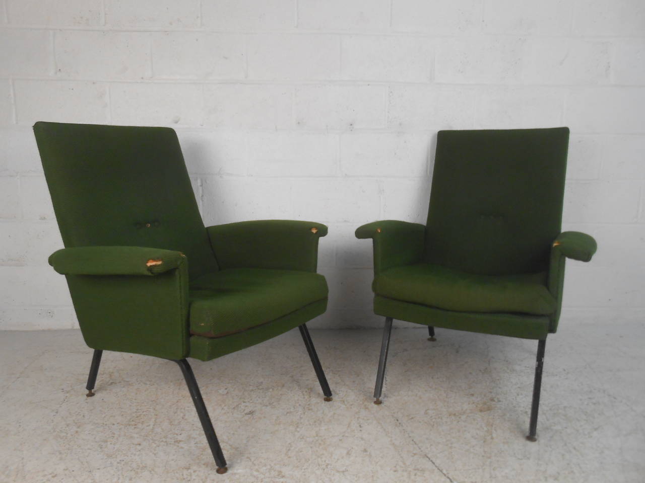 Este elegante par de sillones de salón de mediados de siglo presenta un asiento de respaldo alto, con cómodos reposabrazos tapizados y robustas patas metálicas. Su exclusivo estilo moderno italiano lo convierte en el conjunto perfecto para el hogar