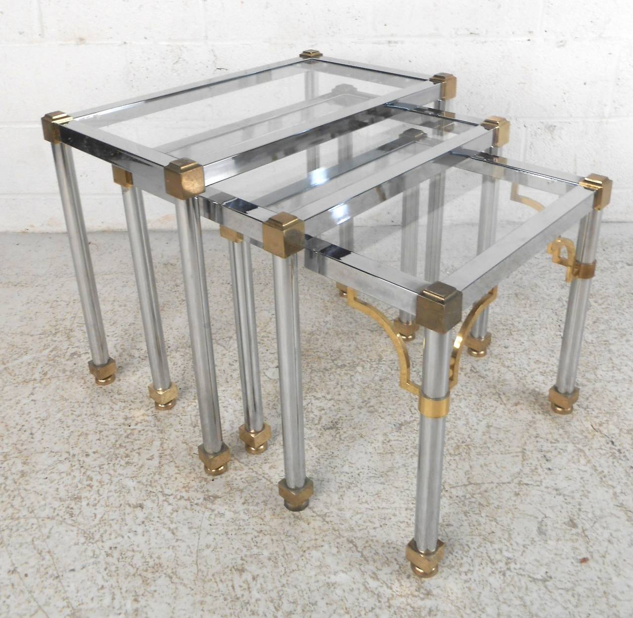 Set of three nesting tables in polished chrome with brass accenting. Made in the manner of Maison Jensen, with glass inset tops.

(Please confirm item location - NY or NJ - with dealer).