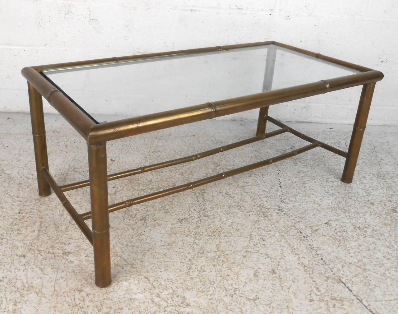 Vintage coffee table in tubular brass with clear glass top. Made in a bamboo style with legs and runners. Natural patina to the brass frame.

(Please confirm item location - NY or NJ - with dealer).