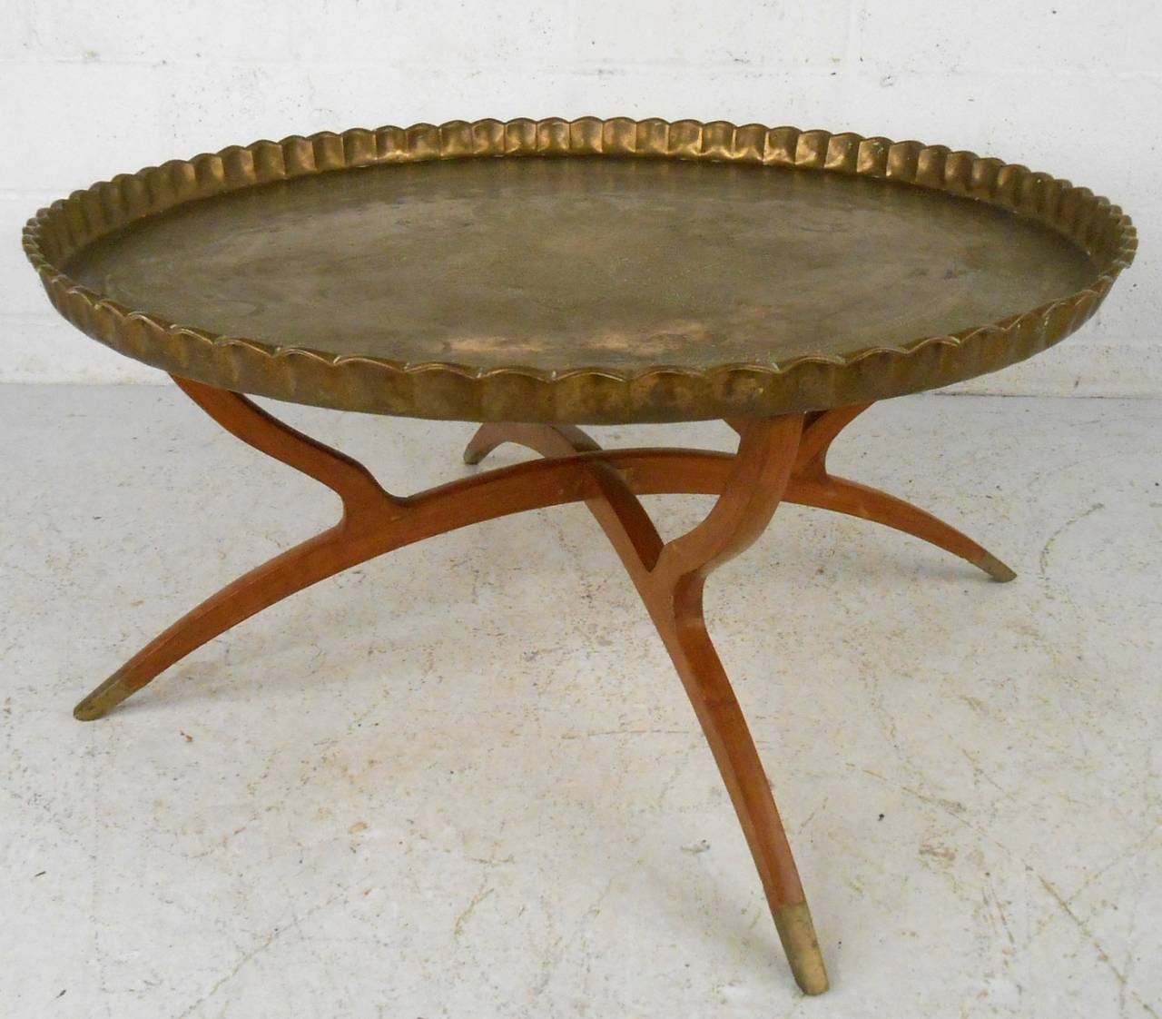 This unique brass tray table sits on folding brass tipped frame and makes a unique center table for any seating are. Unique etching and textured design, please confirm item location (NY or NJ).
