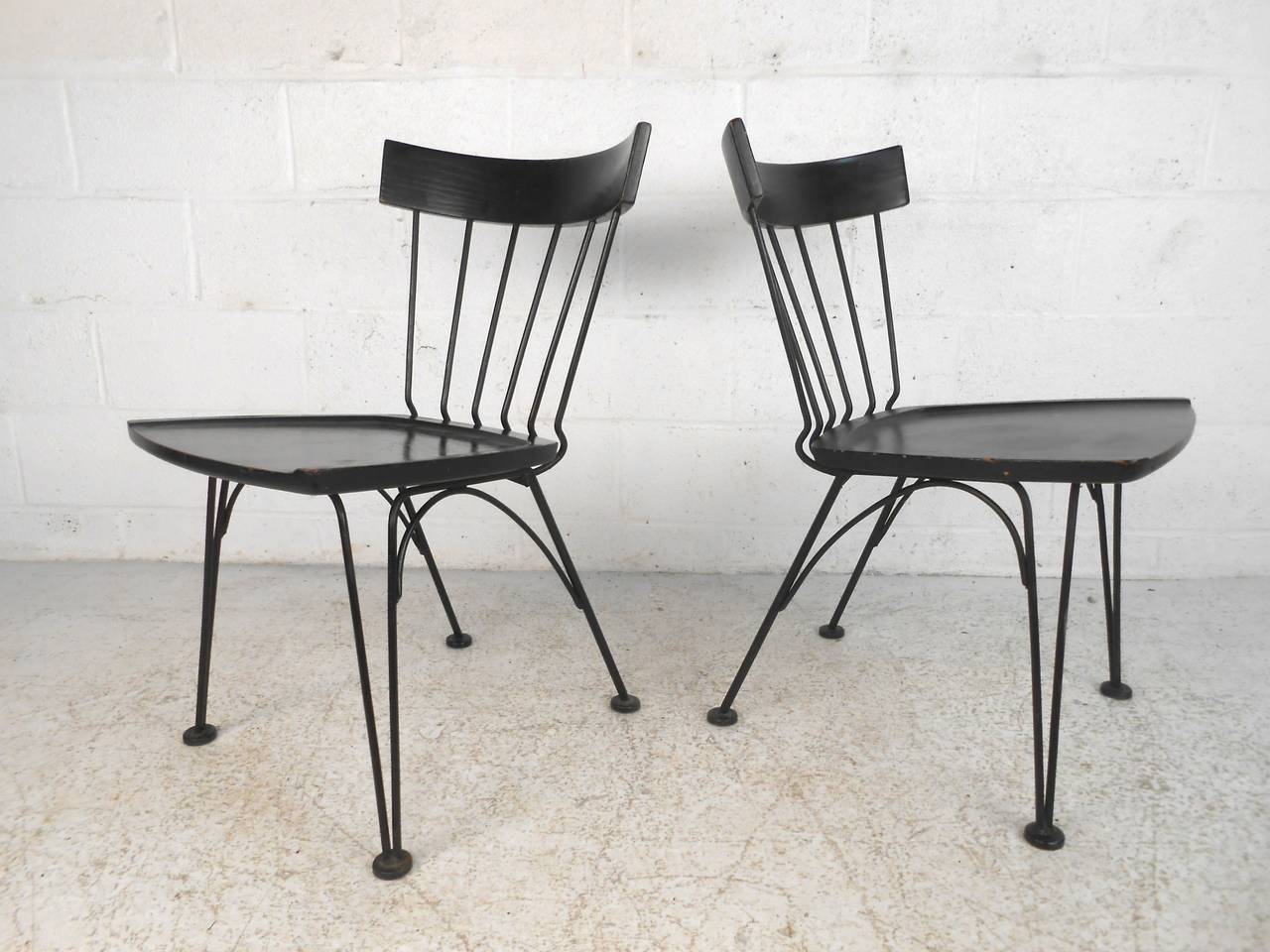 Combining wrought iron frames with sculpted wood seats and backs. Uncommon black finish go well with the sturdy black frames for a sleek modern look. Lee Woodard gives attention to detail in the smooth lines throughout the iron frame, including the