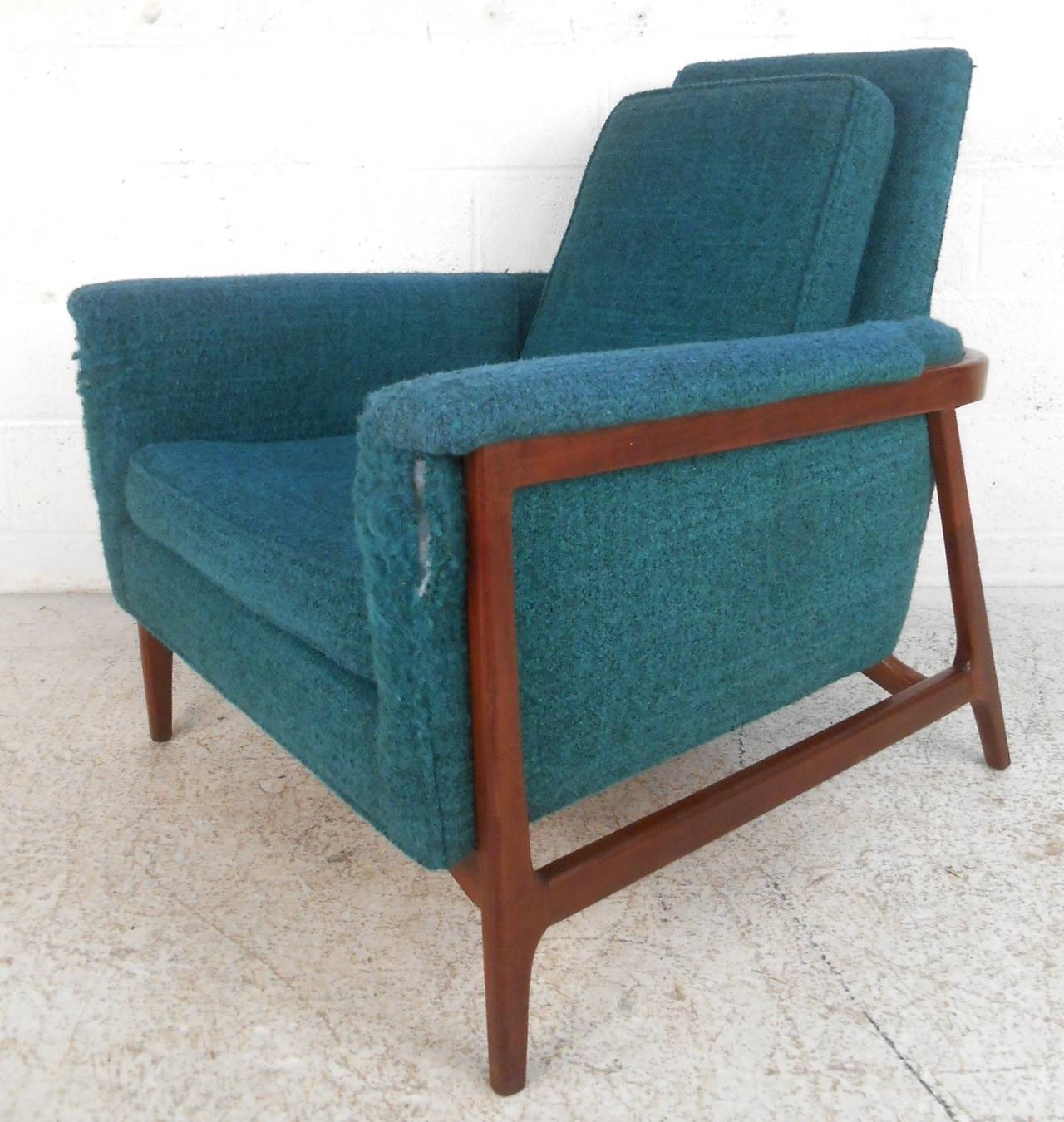 This unique vintage armchair features a truly unique wooden frame, molded armrests, and comfortable high back design. Wonderful lines set apart this lounge chair from the rest and make it a perfect addition to home or business. Please confirm item