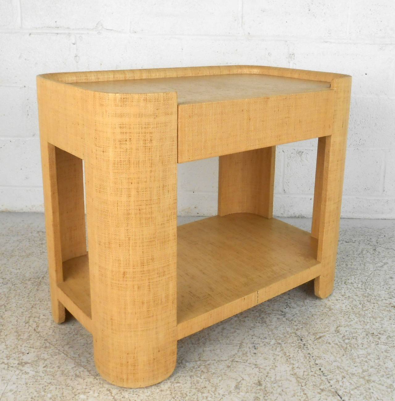 Mid-Century modern side table in grass cloth with pull out drawer. Storage also available on the top and bottom shelves. Ideal for bedroom or living room side table storage.

(Please confirm item location - NY or NJ - with dealer)
