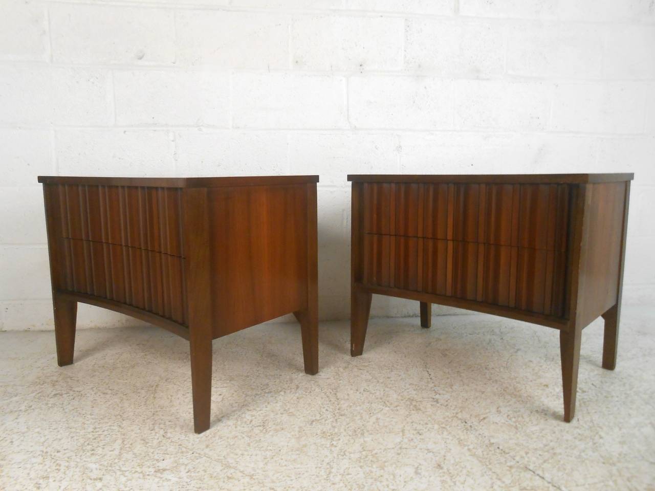 Uncommon style bedside tables by Unagusta for their 'Strata' line. Featuring sculpted drawers and unique bowed front. Walnut grain, tapered legs.

(Please confirm item location - NY or NJ - with dealer)