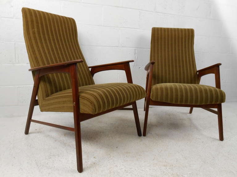 Pair of Scandinavian modern upholstered chairs with teak frames add a splash of mid-century style to any interior. Comfortable and stately pair of lounge chairs make an impressive vintage modern addition to home or business seating. Please confirm
