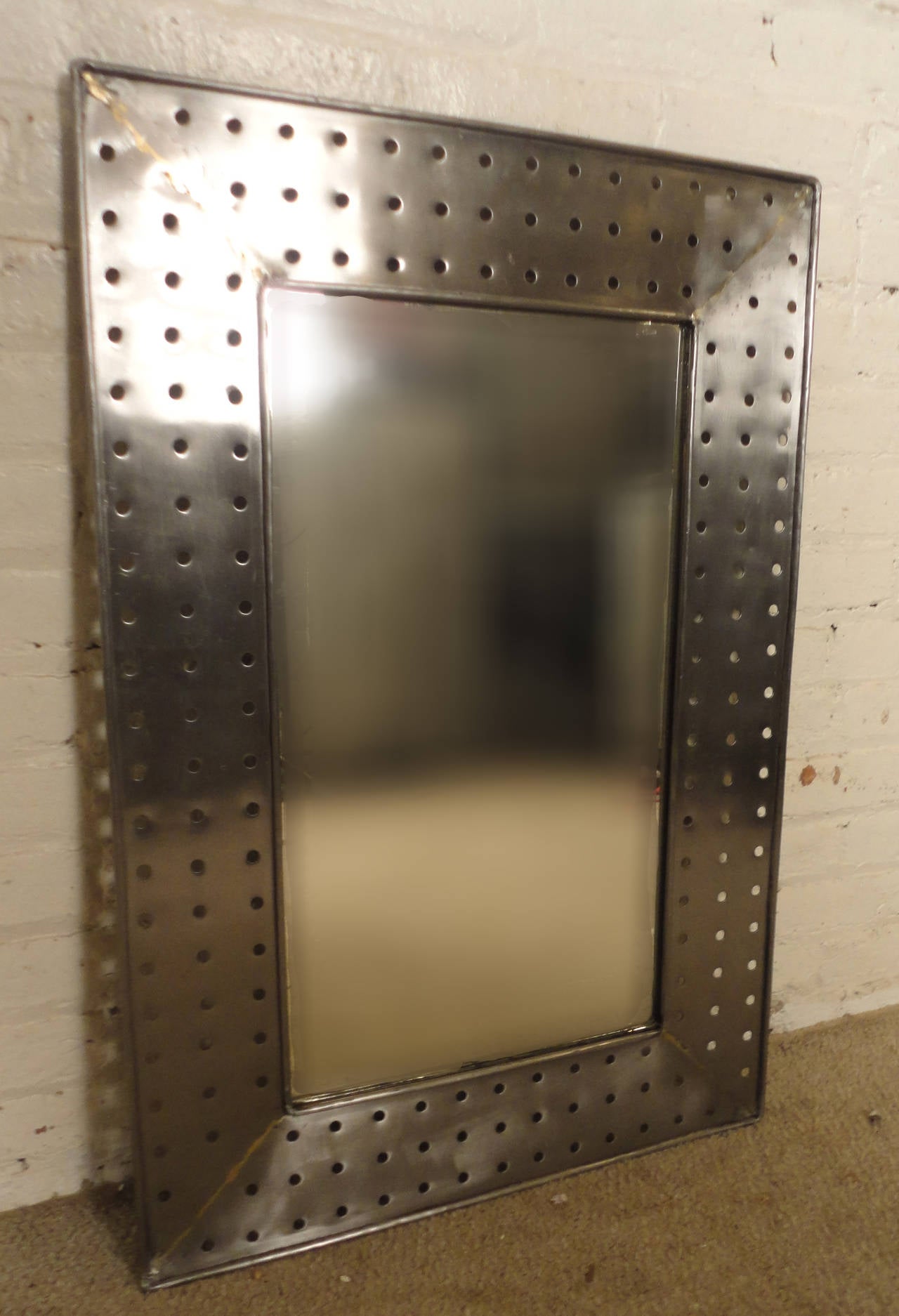 Unique metal mirror with hole punched border. A striking addition to any modern home or office.

(Please confirm item location - NY or NJ - with dealer)