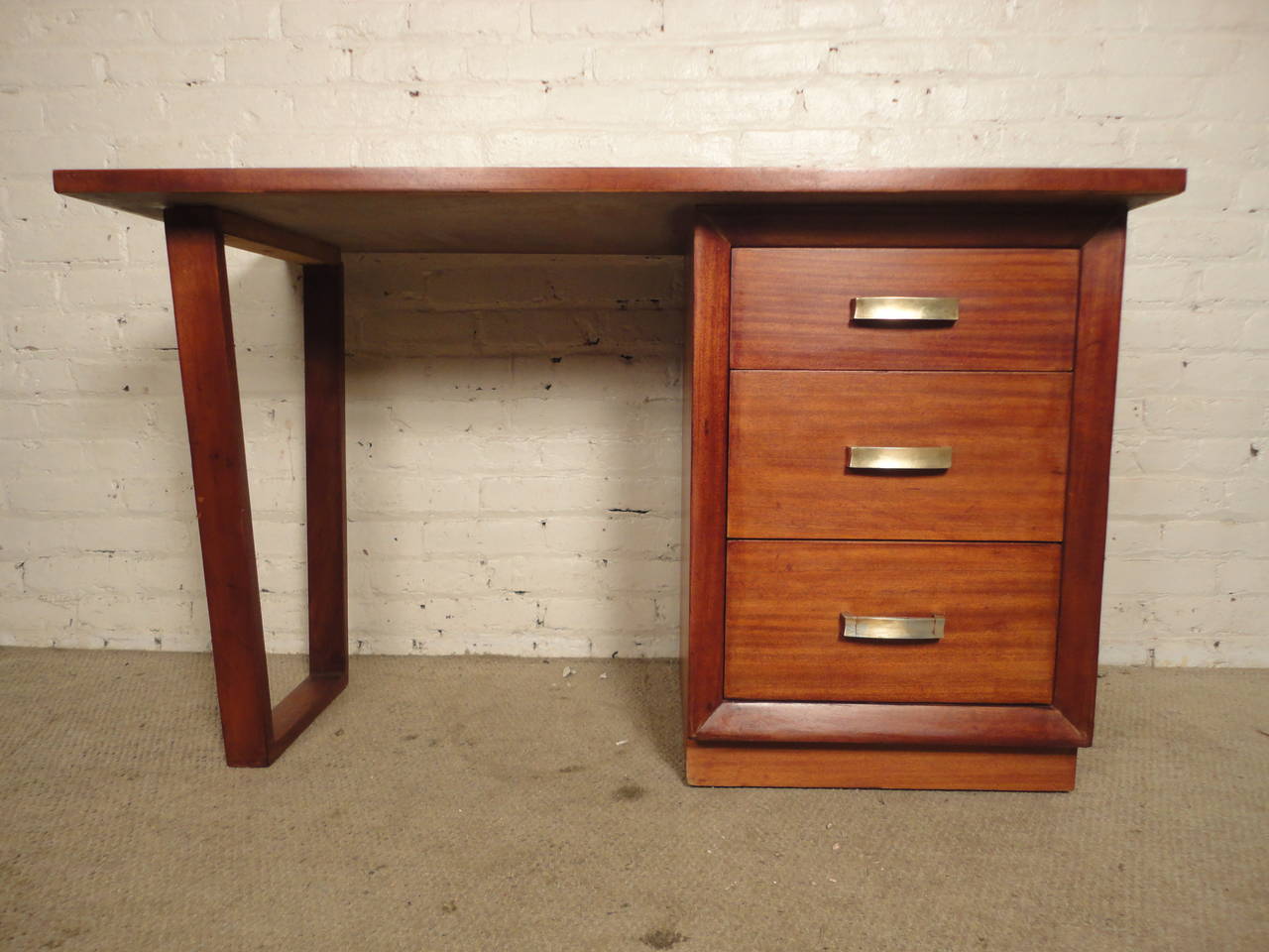 Mid-Century modern desk for John Stuart. Reddish/brown mahogany grain, metal handles, three drawers and sled leg. Simple modern design by John Widdicomb
KNEEHOLE: 22W 19D 29H

(Please confirm item location - NY or NJ - with dealer)