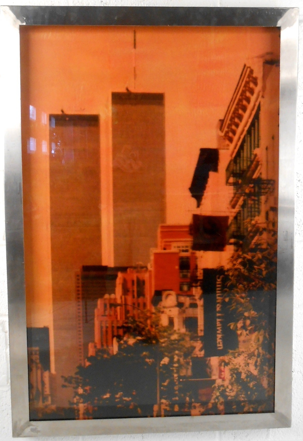 This uniquely framed photograph captures a pre 9/11 World Trade Center through the lens of artist Isack Kousnsky. Known for his colorful interpretations of photographic genius, this beautiful reminder of beloved cityscape makes a unique addition to