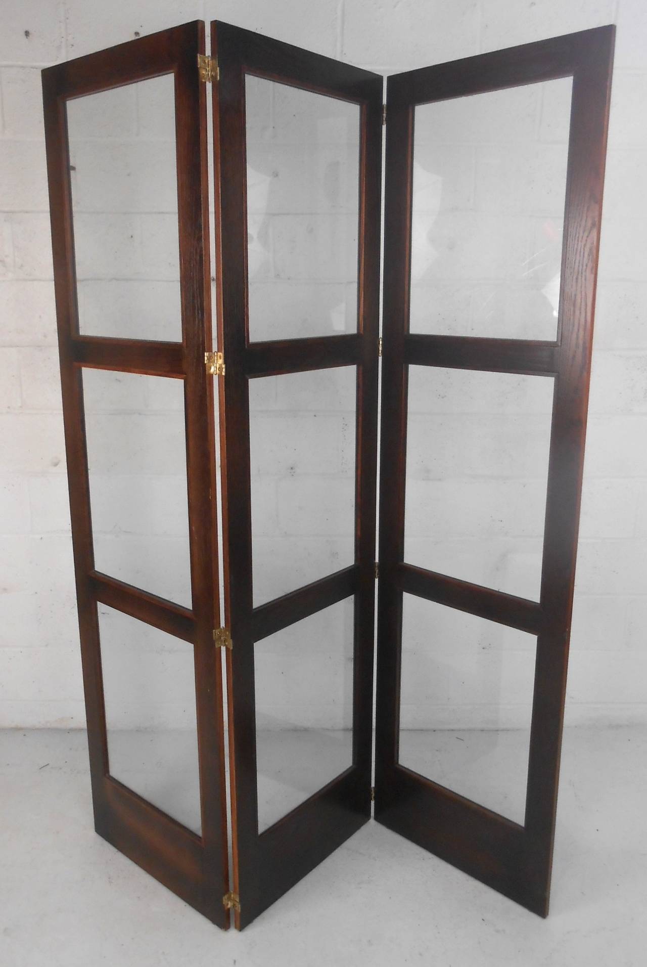 This mid-century hardwood folding screen features vintage glass set in trifold double hinged frame. Unique solution for decor or dividing up living space. Please confirm item location (NY or NJ).